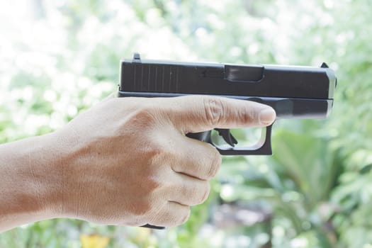 Thai man hand holding black gun