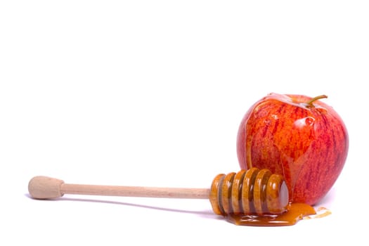 Close up view of a royal gala apple with a honey dipper isolated on a white background.