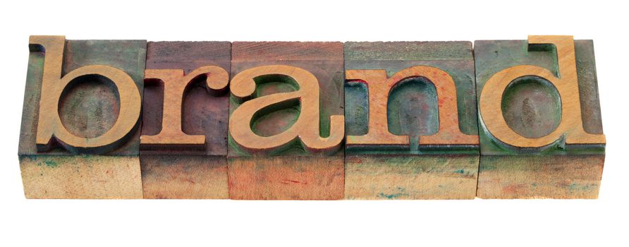 brand word in vintage wooden letterpress printing blocks, stained by color inks, isolated on white