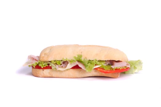 Close view of a fresh tasty ciabatta sandwich with tomato, lettuce, cheese and ham isolated on a white background.