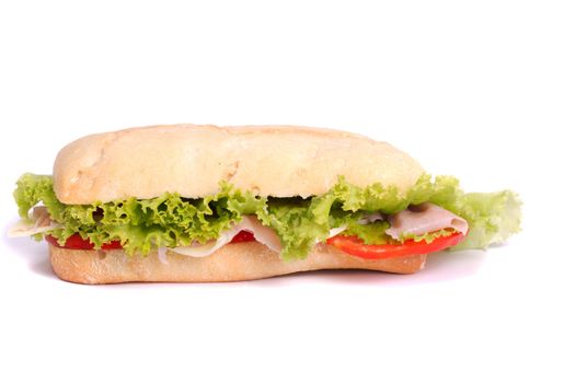 Close view of a fresh tasty ciabatta sandwich with tomato, lettuce, cheese and ham isolated on a white background.
