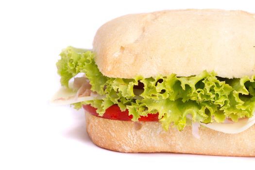 Close view of a fresh tasty ciabatta sandwich with tomato, lettuce, cheese and ham isolated on a white background.