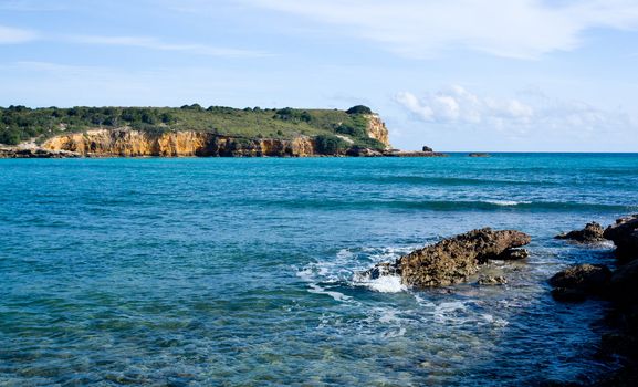 Rocky island in surf off the south west coast of Puerto Rico by Los Morillos Lighthouse