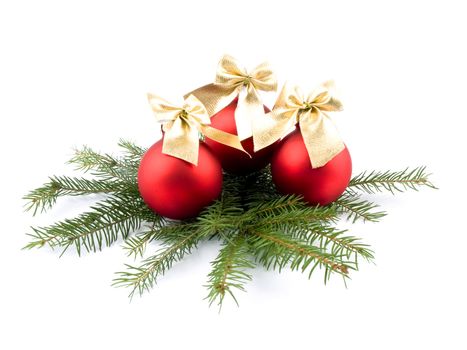 Three red glass balls with nice golden ribbons and fresh spruce on white background