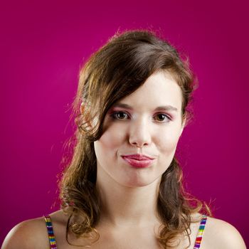 Portrait of a beautiful young woman over a pink background

