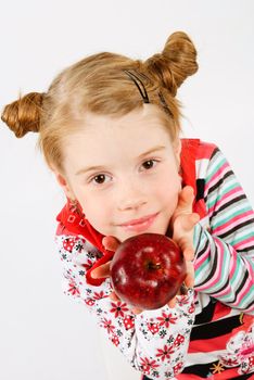 studio shot of pretty little girl offering a red apple