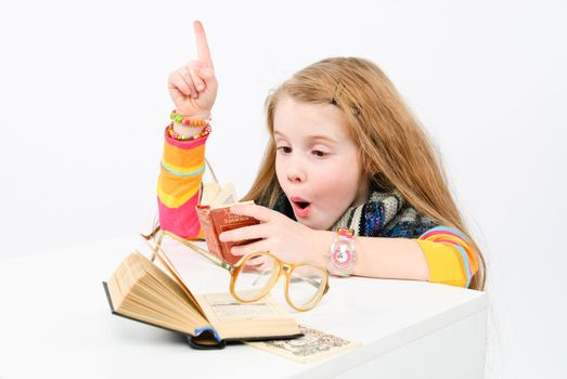 studio shot of pretty little girl reading a book