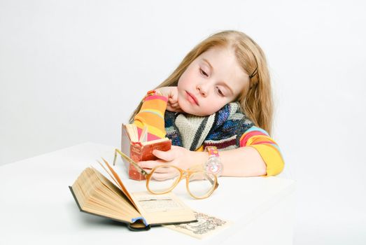 studio shot of pretty little girl reading a book