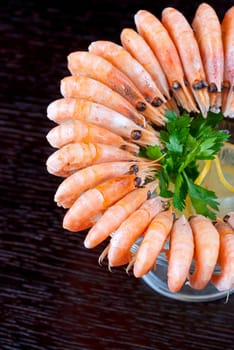 tasty shrimps with lemon and greens closeup