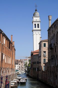 Canal and tower over blue sky in Venice, Italy