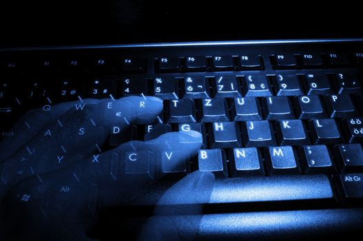computer keyboard with ghost fingers at night