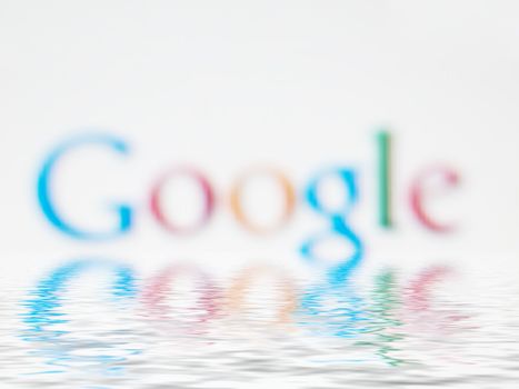Macro of Google search engine company logo on a computer screen wth water effect
