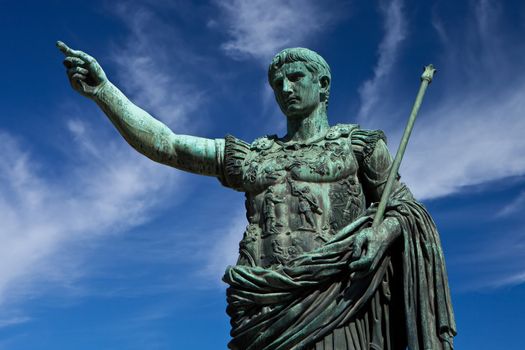 Bronze Roman Statue pointing against a blue sky