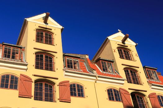 Traditional mustard colour office warehouse against a bright blue sky