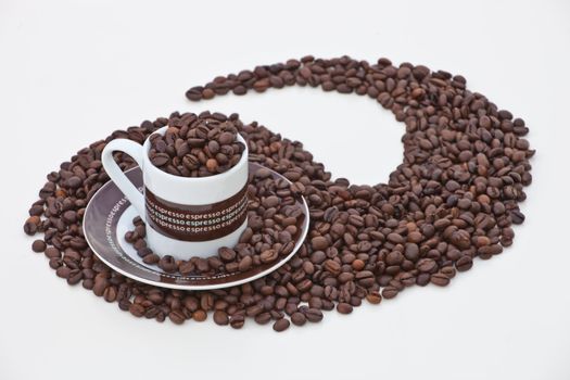 Espresso cup full of whole coffee beans