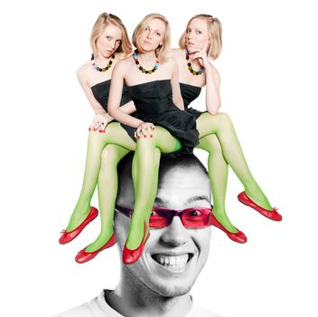 Three women sitting on the man head. Studio photo of the women and man smiling head.