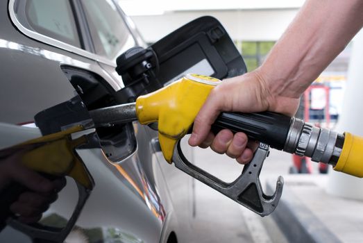 Close-up pumping gasoline on a black car 