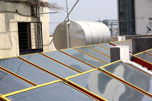 The panels of a solar water heater with its tank installed on a terrace.