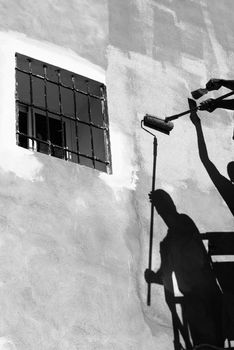 Shadows of two painters on a building facade