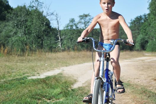 innocent little kid on bicycle in forest