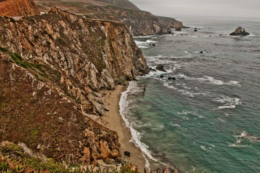 Waves hitting the rugged coastline in Big Sur California