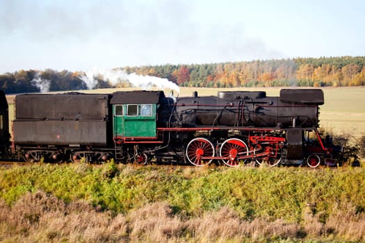 Old retro steam train passing through polish countryside
