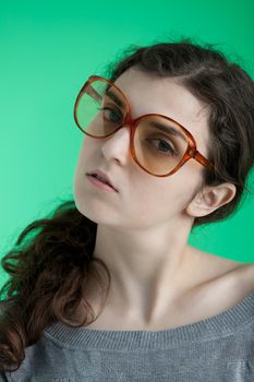 girl with big glasses on a green background