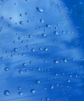 Small water droplets on a transparent blue surface