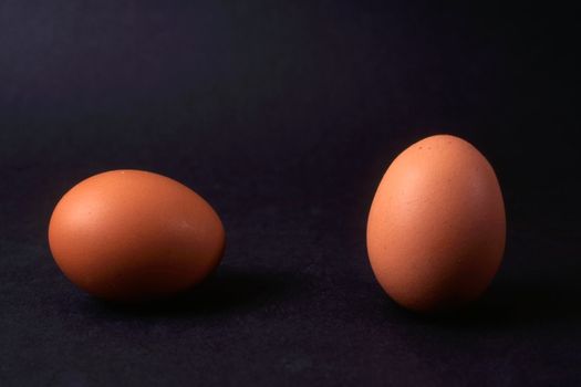 Two eggs isolated on black background