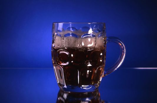 A glass of beer isolated on blue background
