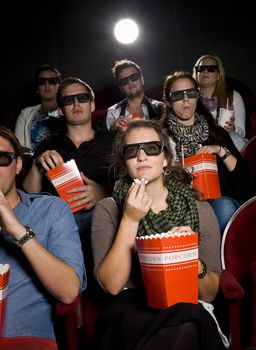 Spectators eating popcorn at the movie theater