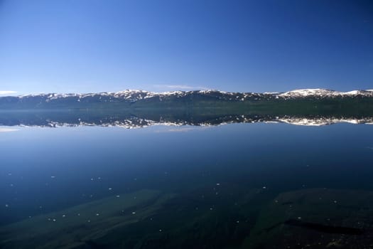 Mirrow lake with snow mountain in Norway