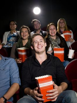 Young man at the movie theater with bag of popcorn