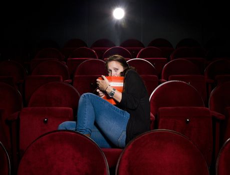 Afraid young woman alone in the movie theater