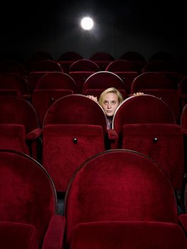 Afraid young woman alone in the movie theater