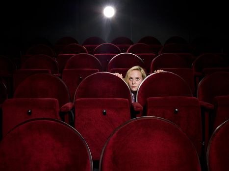 Afraid young woman alone in the movie theater