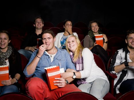 Young Couple at the Movie Theater eating popcorn