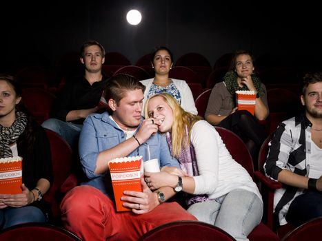 Young Couple at the Movie Theater eating popcorn