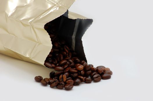 gold bag with coffee beans isolated on the white background