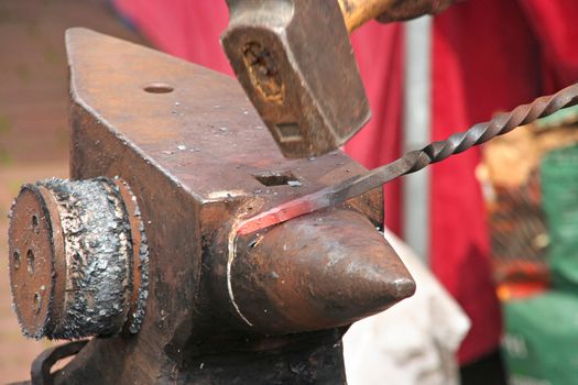 Hammer hitting on hot metal on classic anvil