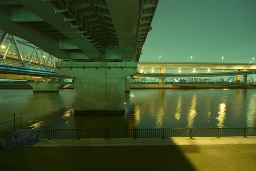huge bridges construction at acid night illumination over Arakawa River, Tokyo Japan