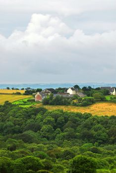 Scenic view on agricultural landscape with a farm house in rural Brittany, France