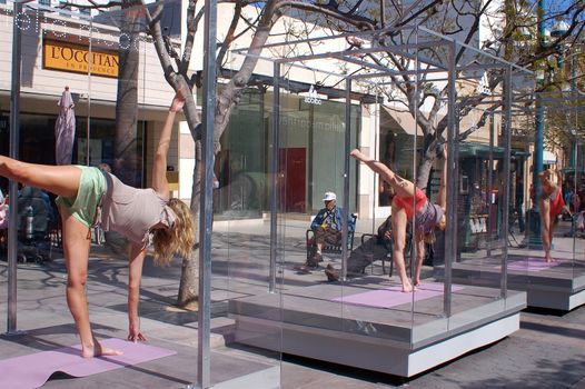 Girls in glass boxes on 3rd Street Promenade (Santa Monica, CA) giving a yoga demonstration.