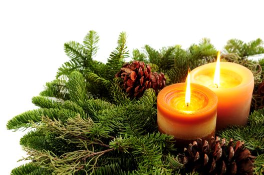 Christmas arrangement of burning candles and green spruce branches on white background