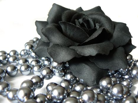 Black rose and beads isolated on white