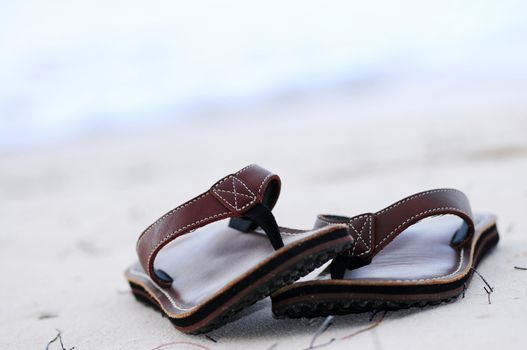 Flipflops on a sandy ocean beach - summer vacation concept