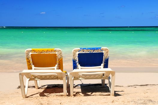 Two vacation chairs on sandy beach of Caribbean island