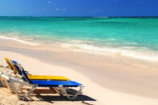 Two vacation chairs on sandy tropical beach of Caribbean island