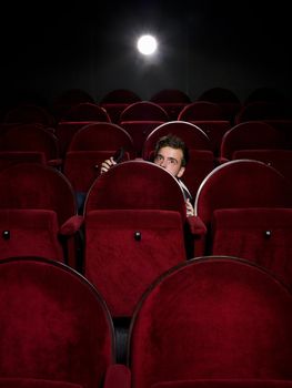 Afraid young man alone in the movie theater