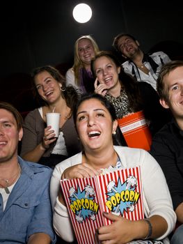 Laughing woman at the cinema with large bag of popcorn